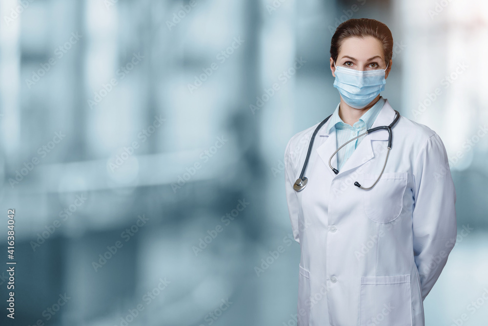 Doctor in a protective mask stands . Doctor in a protective mask stands .