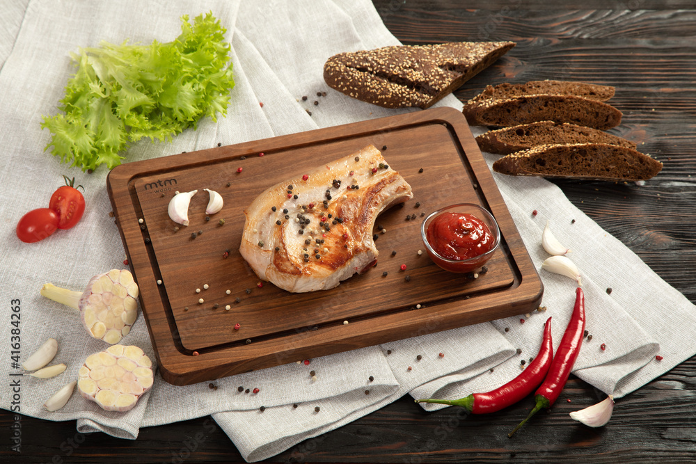 Fried pork entrecote on a board for serving.