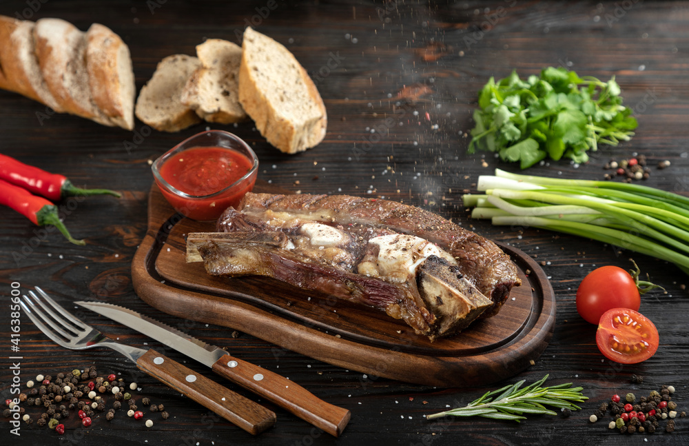 Roasted beef on the bone on a board for serving.