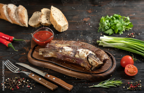 Obraz na płótnie Roasted beef on the bone on a board for serving. w salonie