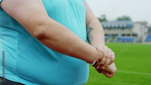 Handsome obese young man stretching hands before start to run in the stadium at the starting line he wearing sports outfit photo