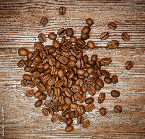 Coffee beans are scattered on a wooden background.