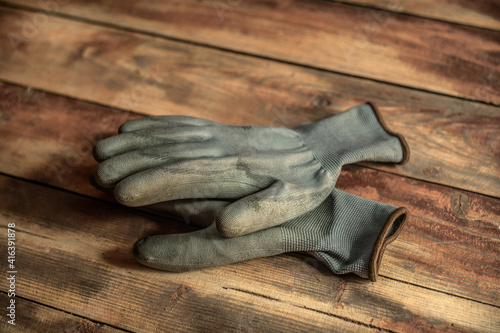 Dirty gray gloves, lying on the wooden floor