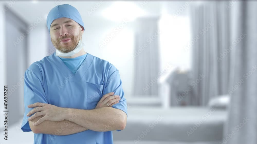 A male surgeon wearing blue medical suit in the hospital ward A male surgeon wearing blue medical suit in the hospital ward