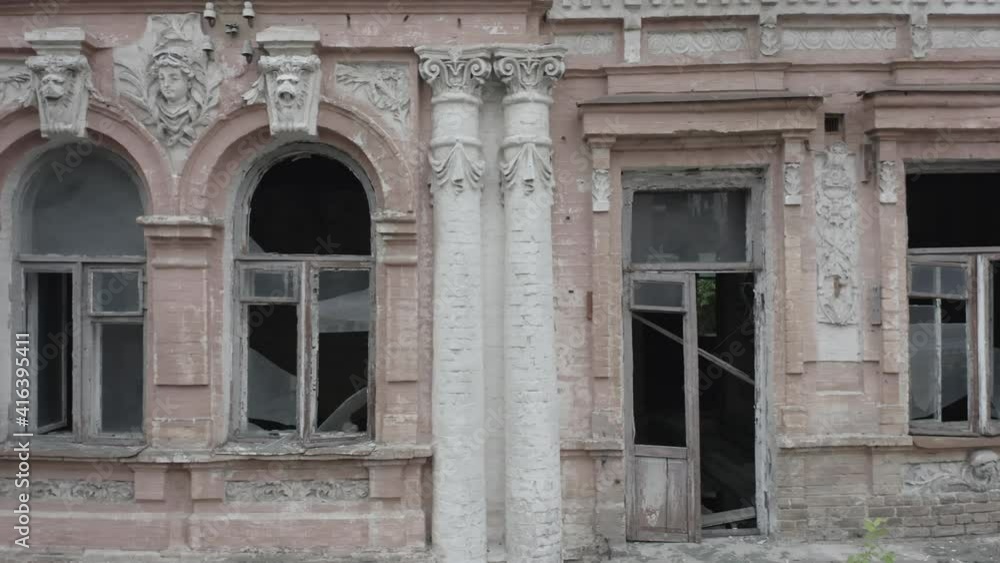 Broken windows of an abandoned old manor (mansion) house in the neoclassical style with an abundance of decor. Deserted building of the 19th century. Shot in log profile. Aerial side view. Close-up Broken windows of an abandoned old manor (mansion) house in the neoclassical style with an abundance of decor. Deserted building of the 19th century. Shot in log profile. Aerial side view. Close-up