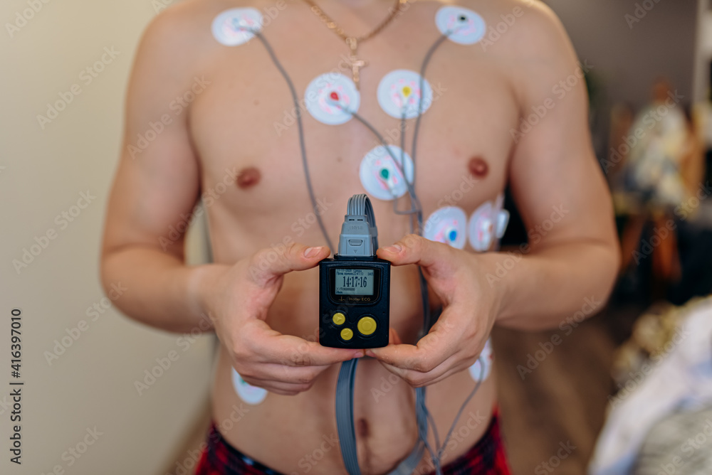 Fototapeta premium Heart electrocardiogram or monitoring using Holter for young patient. Male athlete does a cardiac stress test. wearing Holter monitor device for daily monitoring of an electrocardiogram. 