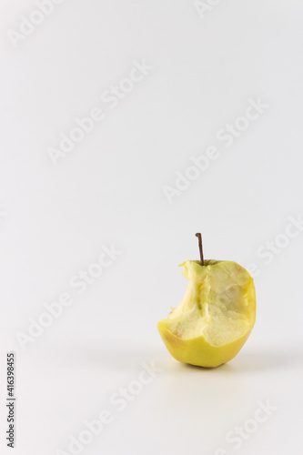 Golden green delicious bitten apple isolated on white. Vertical photo an apple stub