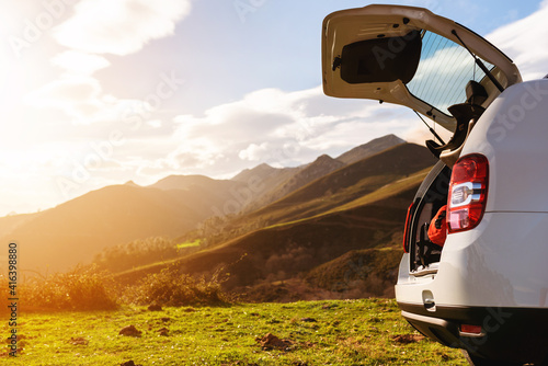 Open off-road car trunk with luggage inside on a mountain at sunset. holidays and weekends. Active turism.