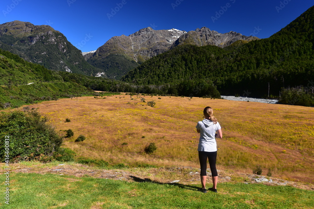 Female tourist enjoying view of lower Routeburn Valley, New Zealand