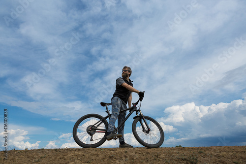 Fototapeta Naklejka Na Ścianę i Meble -  Sports brutal bearded guy on a modern mountain bike. A cyclist in a salt deserted place by the lake.