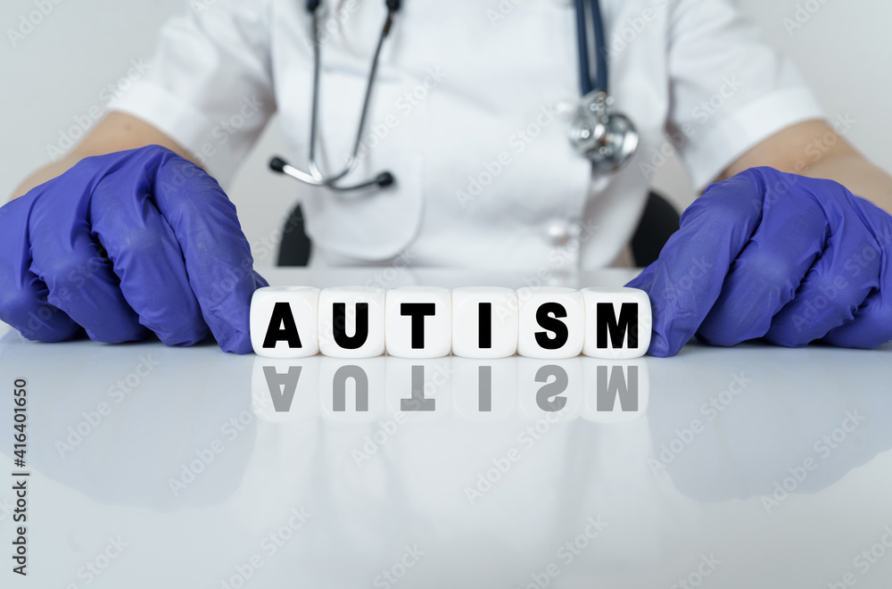 The doctor put together a word from cubes AUTISM The doctor put together a word from cubes AUTISM