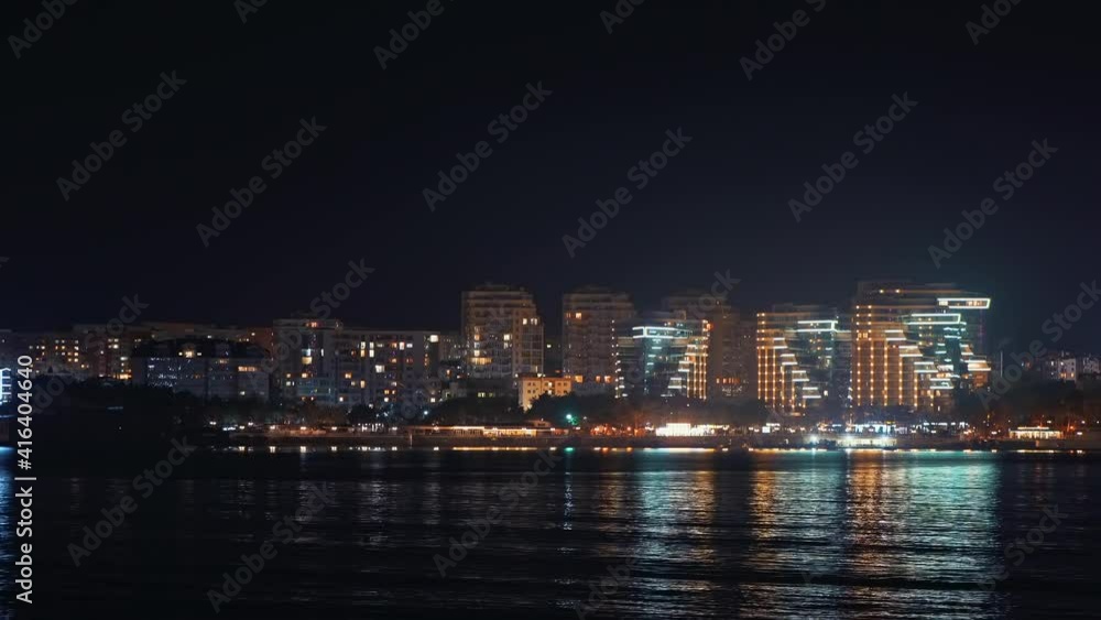 Panoramic view of Gelendzhik city resort seafront at night with illuminated modern buildings reflected in sea water. Panoramic view of Gelendzhik city resort seafront at night with illuminated modern buildings reflected in sea water.