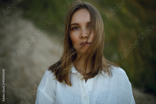 portrait of a young girl in white clothes on a blurred background of the forest. tenderness and loneliness