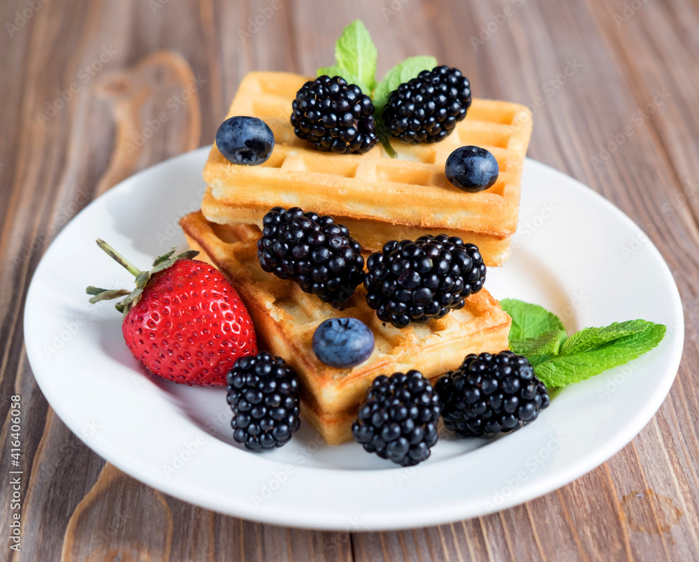 Sweet Homemade Berry Belgian Waffle on white plate Sweet Homemade Berry Belgian Waffle on white plate