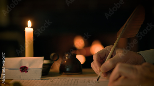 vintage scene of a man writing with a quill pen in front of a fireplace