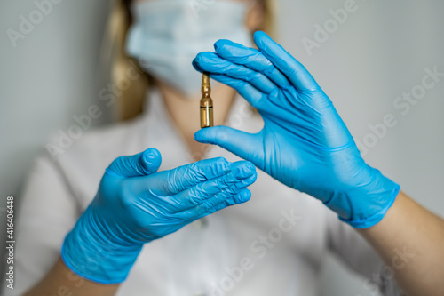 A woman holds medical vial or ampoule. Vaccine. The ampoule with the medicine.