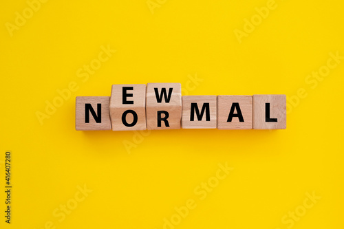 New normal word wooden alphabet cube. Yellow background