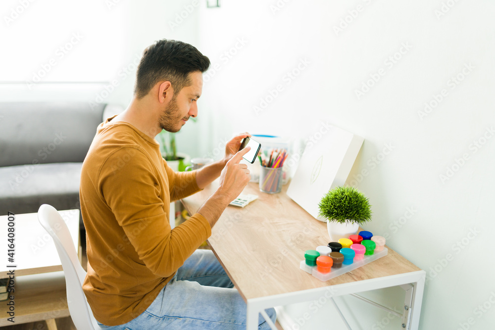 Hispanic man feeling proud of his watercolor painting Hispanic man feeling proud of his watercolor painting