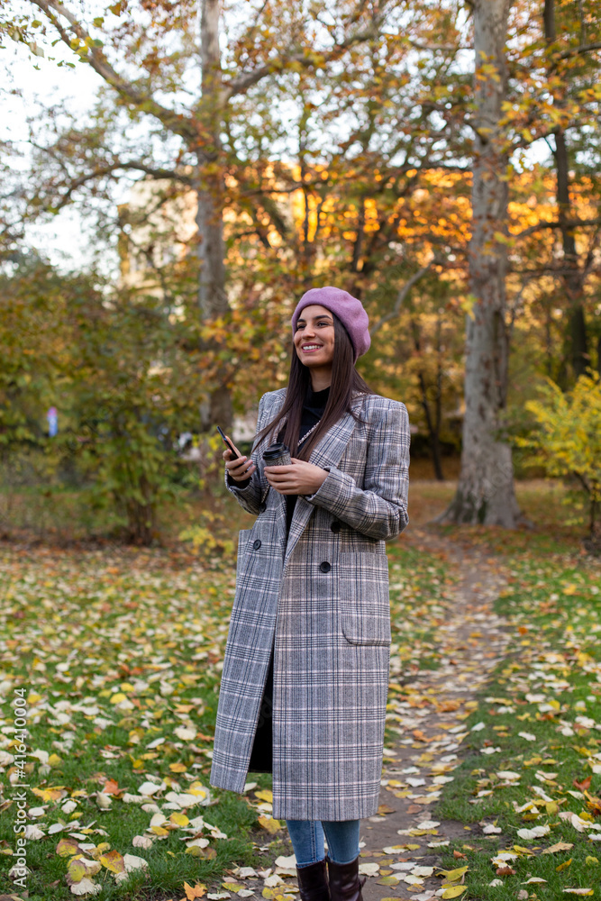 Portrait of a young woman holding coffee cup in the park. Portrait of a young woman holding coffee cup in the park.