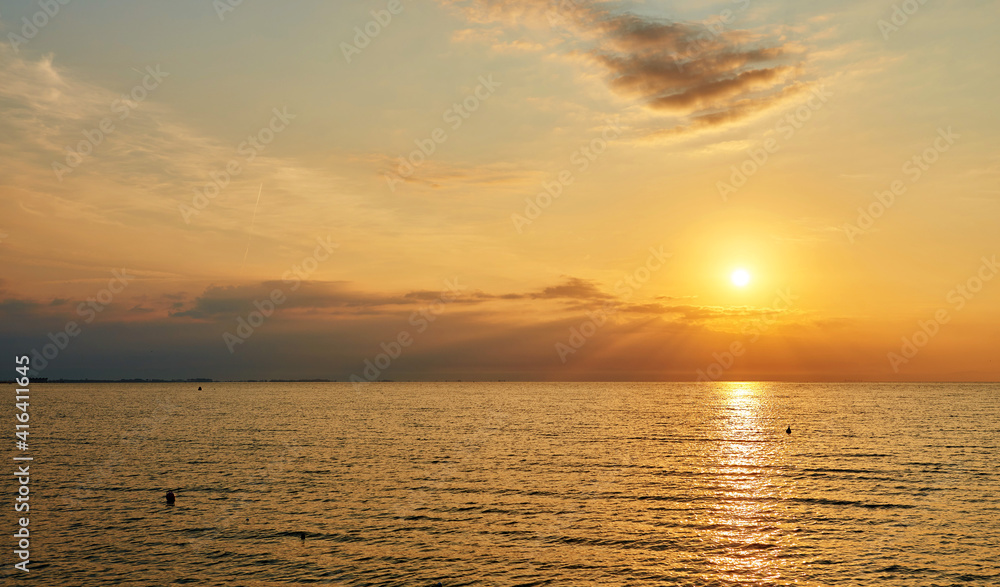 Amazing Sunset on the Sea. Adriatic sea, beautiful sunset, waves and landscape.  Lignano Sabbiadoro, Italy.