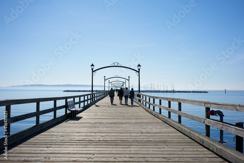 Family walking on the White Rock pier during a sunny spring day. 