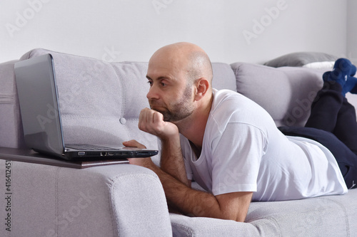 Young man in livingroom using laptop