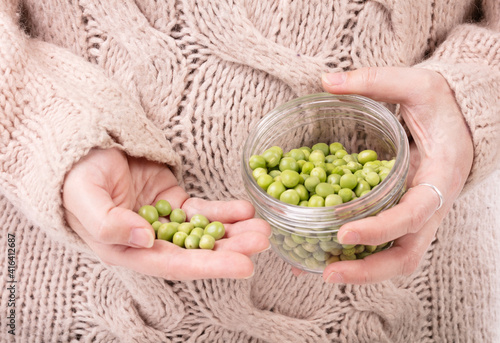 Jar of raw peas in the hands of a woman
