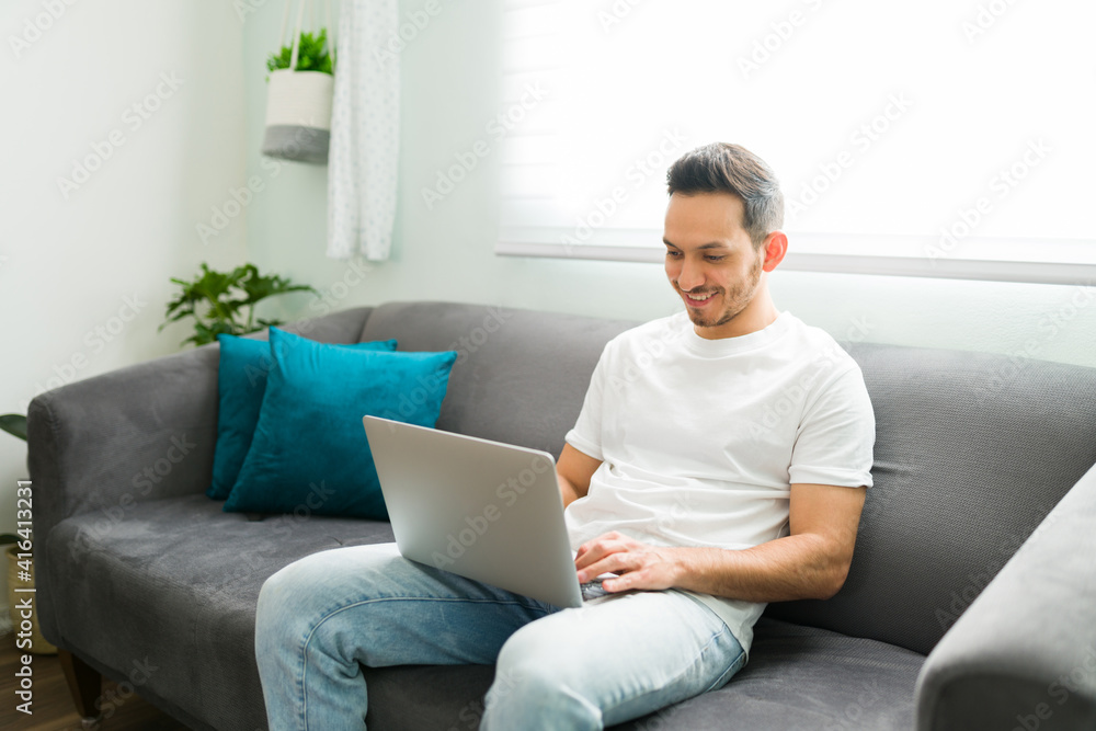 Handsome guy typing on the computer during a relaxing day Handsome guy typing on the computer during a relaxing day