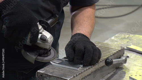 A man cleans the detail from deburring machine.