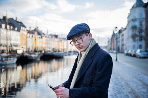 Photography Elegant dressed businessman checks his phone while he is away from home