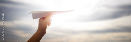 Photos man about to launch a paper plane on a beautiful afternoon