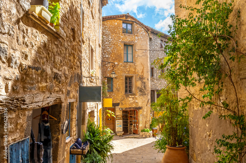 Fototapeta Naklejka Na Ścianę i Meble -  Small shops on an ancient street inside the medieval walled stone village of Tourrettes Sur Loup in the Provence Alpes Maritimes area of South France.