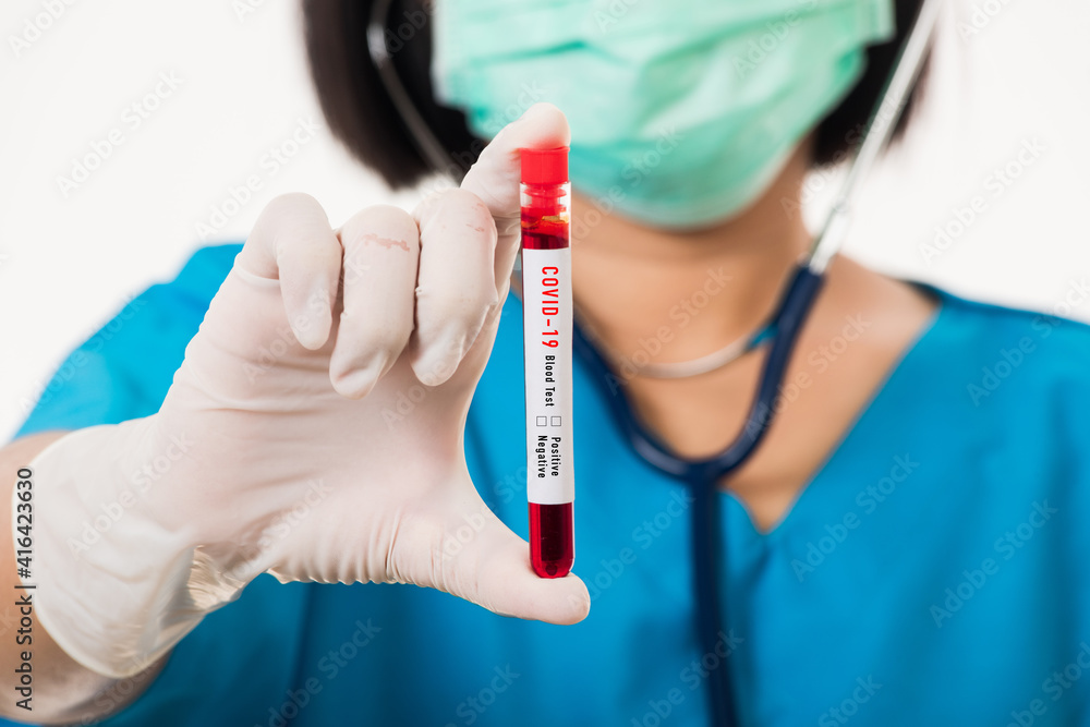 Nurse in blue uniform wear a mask holding test tube sample Coronavirus test blood in the laboratory for analyzing isolated on white background, medicine COVID-19 pandemic outbreak concept Nurse in blue uniform wear a mask holding test tube sample Coronavirus test blood in the laboratory for analyzing isolated on white background, medicine COVID-19 pandemic outbreak concept