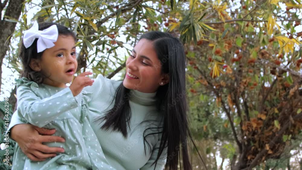 Madre habla con su hija sentadas en un parque
