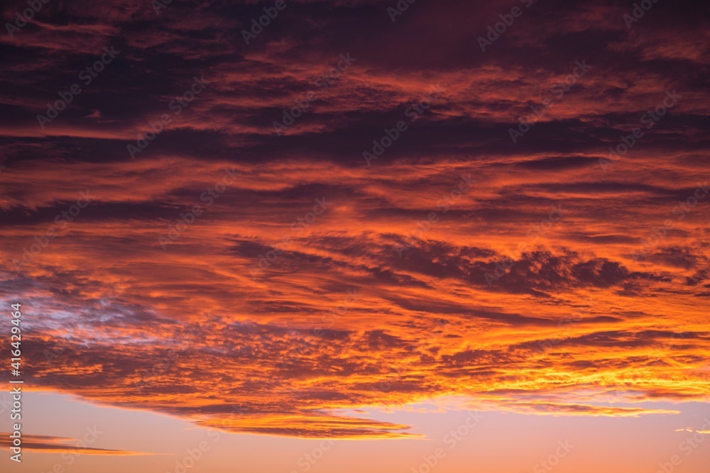 This image shows a vast sunset sky filled with large clouds. 