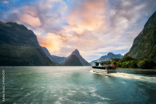 A Cruise going into Sunset at Milford Sound, a fiord in the southwest of New Zealand’s South Island. Milford Sound is a fusion of spectacular natural features, rainforests, and waterfalls.