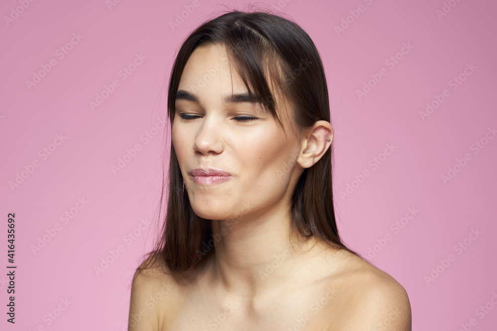 Woman with bare shoulders hair care makeup clean skin pink background Woman with bare shoulders hair care makeup clean skin pink background