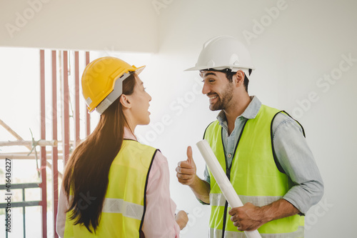 Team of cheerful young caucasian,asian man and woman contractor, partner showing agree together and inspecting the reconstructed construction and renovated to check defect of apartment, home at site.