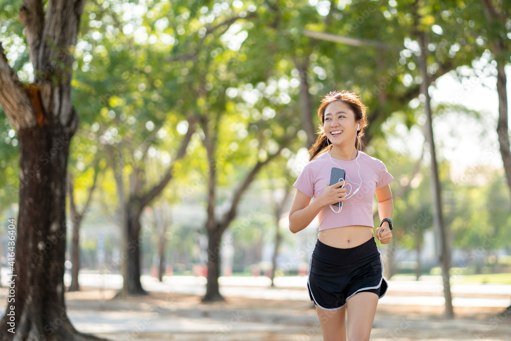 Healthy Asian woman jogging in the morning in the park, sport concept. Healthy Asian woman jogging in the morning in the park, sport concept.