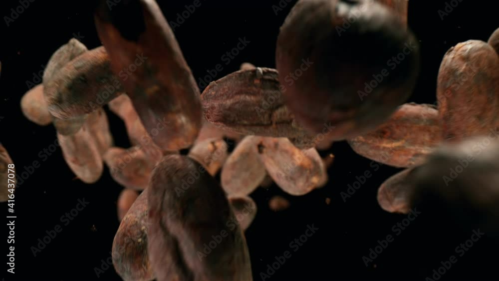 Super slow motion of flying roasted cocoa beans on black background. Filmed on high speed cinema camera, 1000fps.
