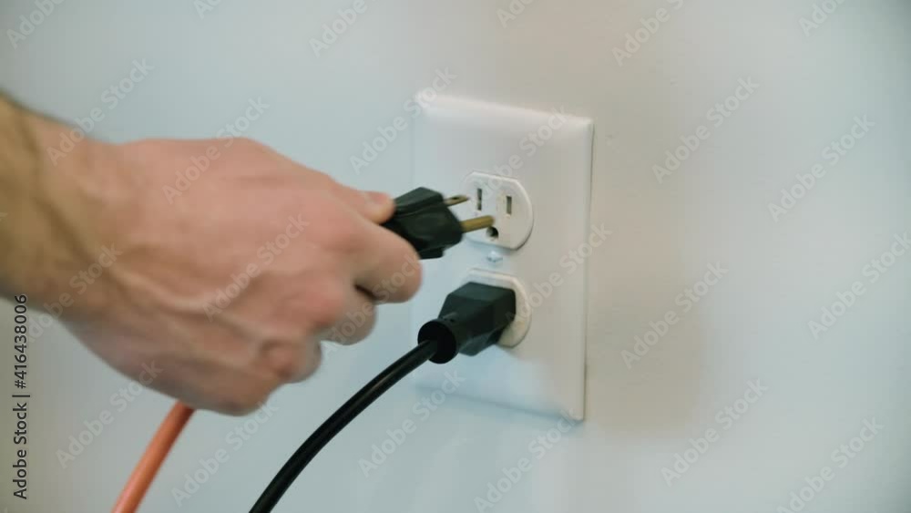 Extension Cord plugged into an electrical outlet in the wall several