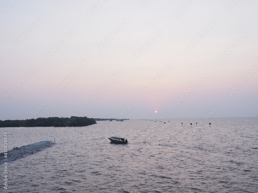 The morning sun rises where tourists are popular to come to visit the sea temple and see the local fishermen lifestyle next to the sea