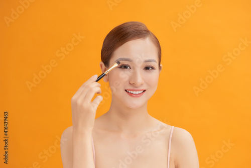 a young woman having eyeshadow added to her eyelids