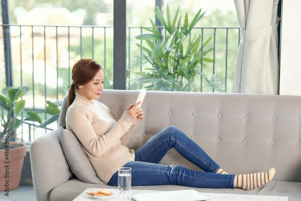 Happy millennial girl checking social media holding smartphone at home