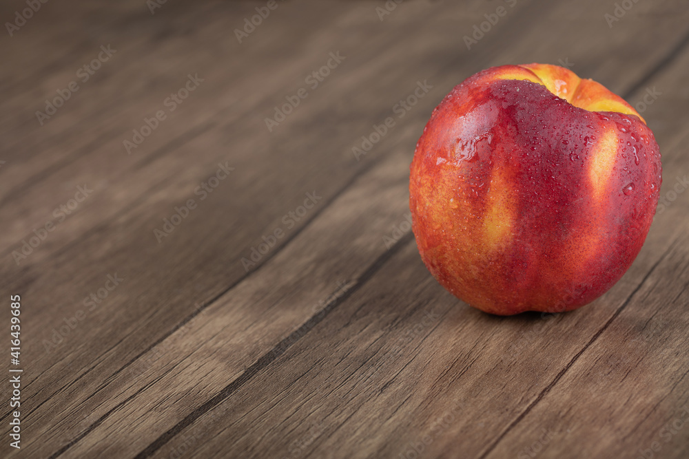 Red yellow peach isolated on a wooden table Red yellow peach isolated on a wooden table