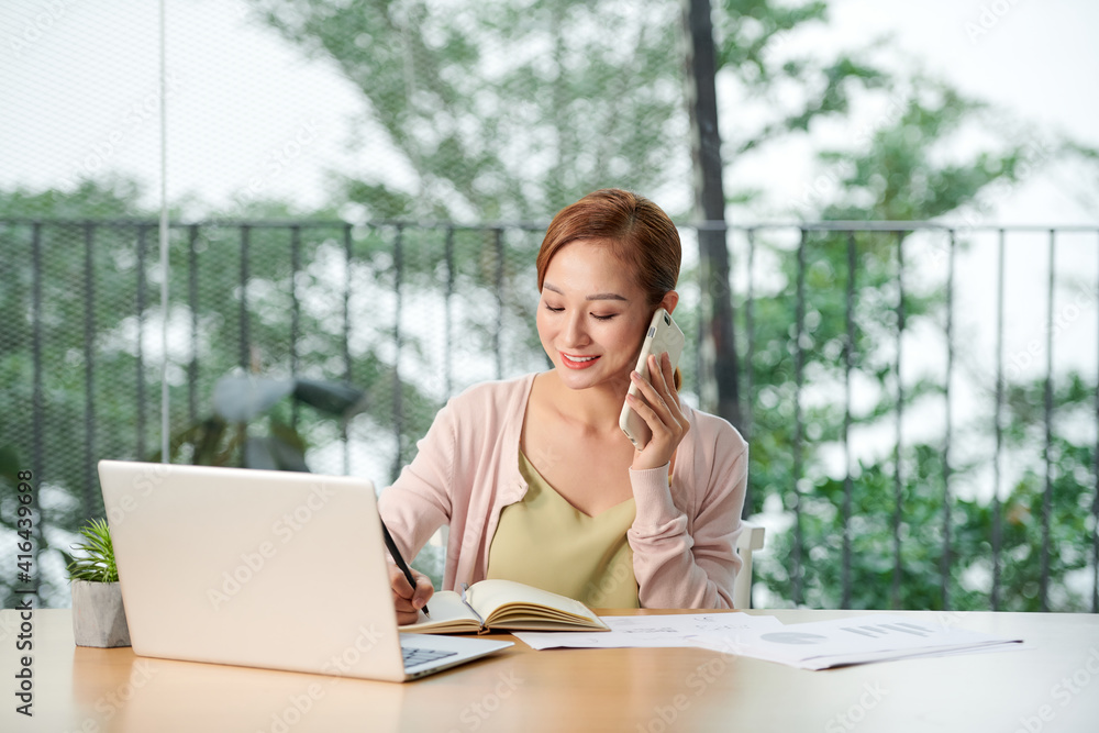 Young woman talking on phone in office Young woman talking on phone in office