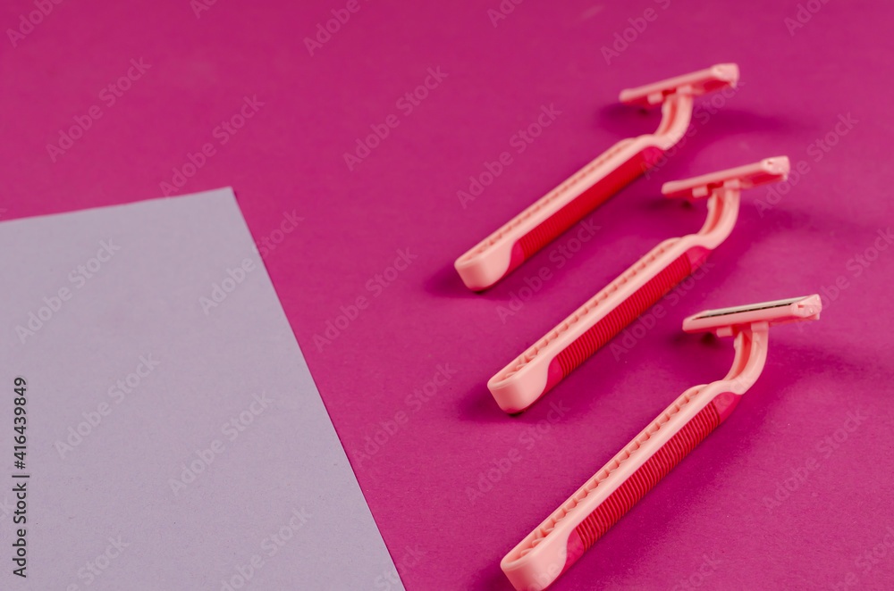 Pink plastic razors on a pink background. Pink plastic razors on a pink background.