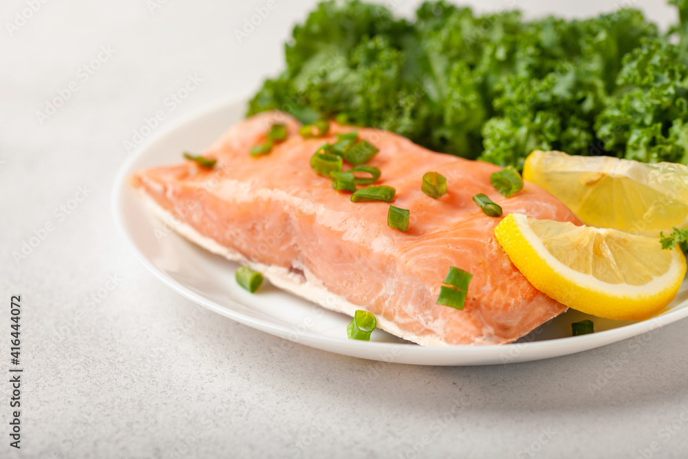 Steam salmon with lemon and salad Kale in a plate on the table. Diet Keto nutrition