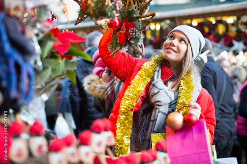 Girl shopping on street selecting decoration for home on Christmas market