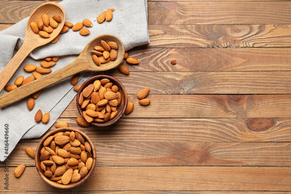 Bowls of almonds on wooden background Bowls of almonds on wooden background